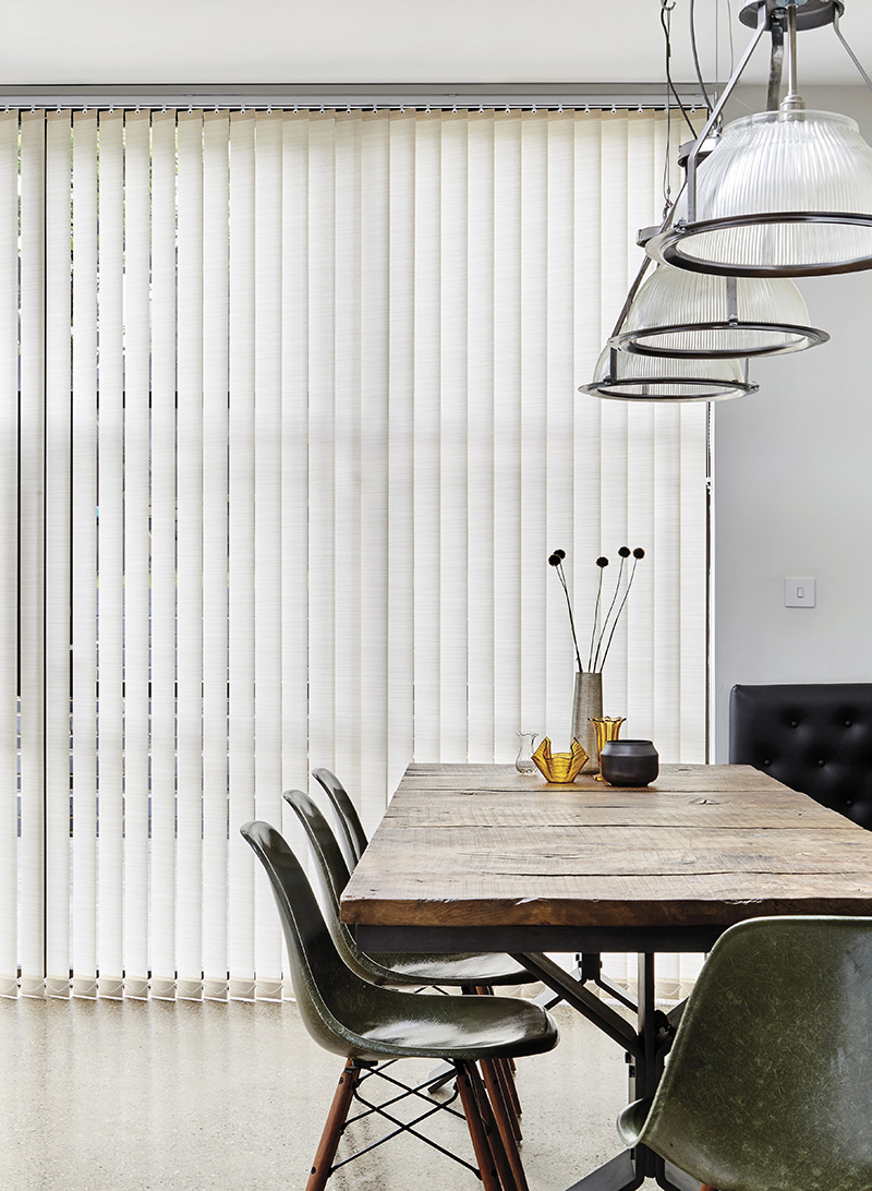 white vertical blinds in dining area with table and chairs.