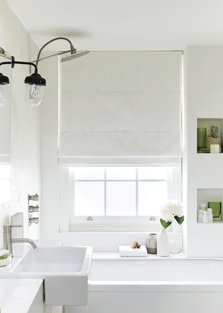 image of bright white themed bathroom using white roman blind