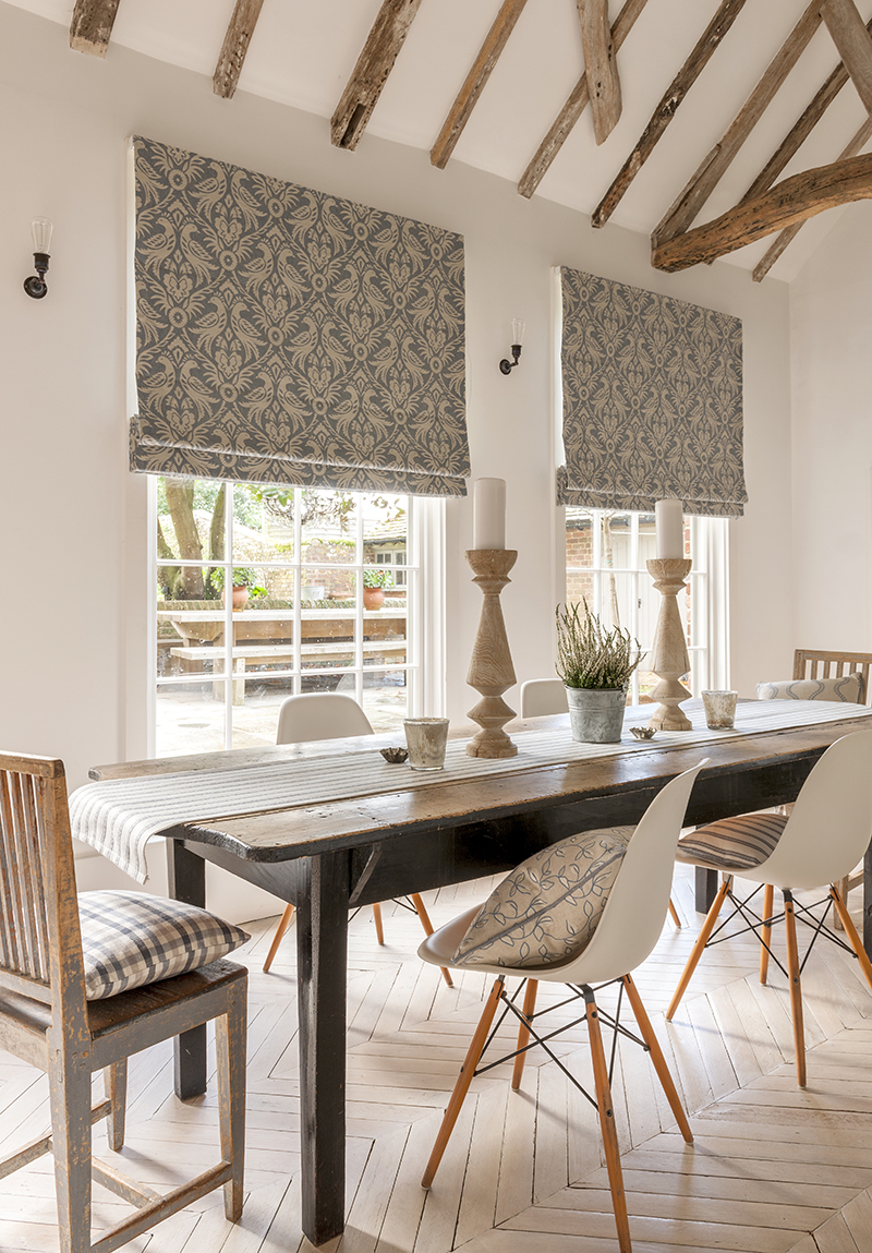 image of open planned dining room next to large windows using roller blinds 