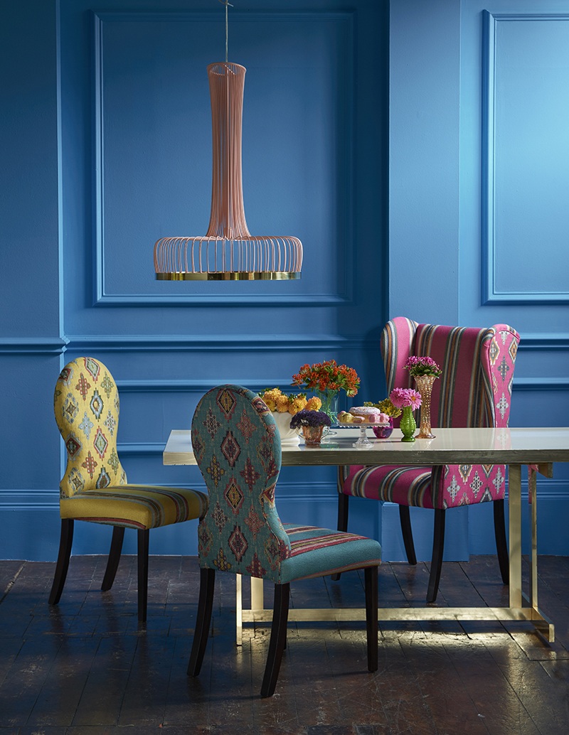 image of bright blue dining room with colourful chairs in front of table 