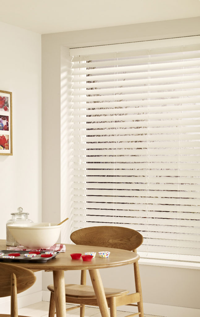 White wooden blinds in dining room.
