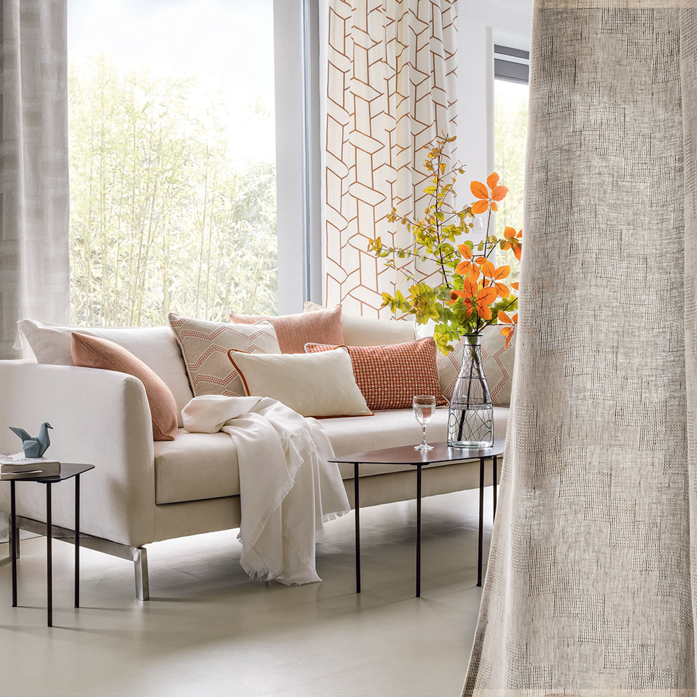 photo of neutrally toned living room with sofa next to large window 