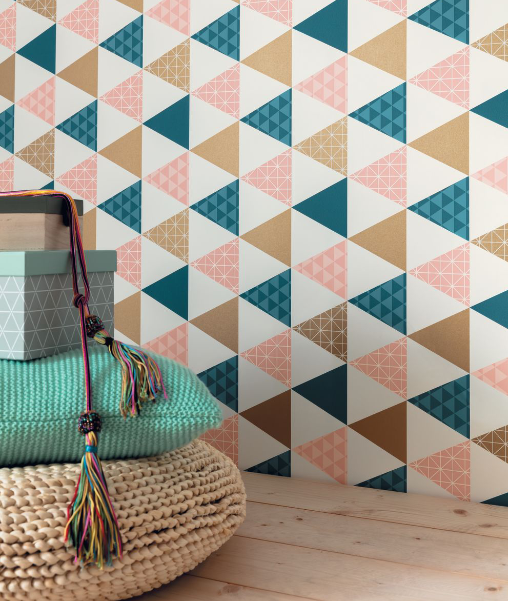 geometric printed wallpaper with teal coloured cushion next to it 