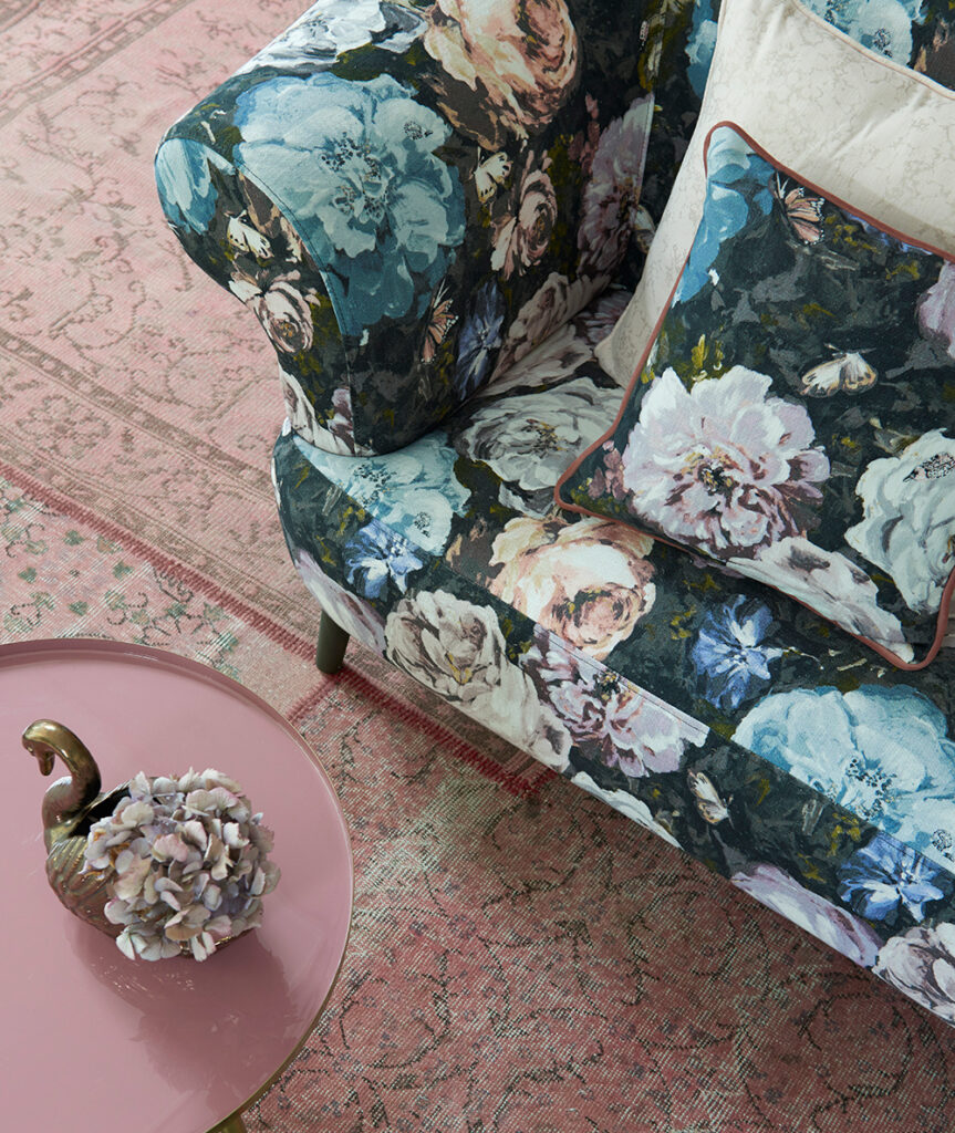 image of floral printed sofa with pink table next to it