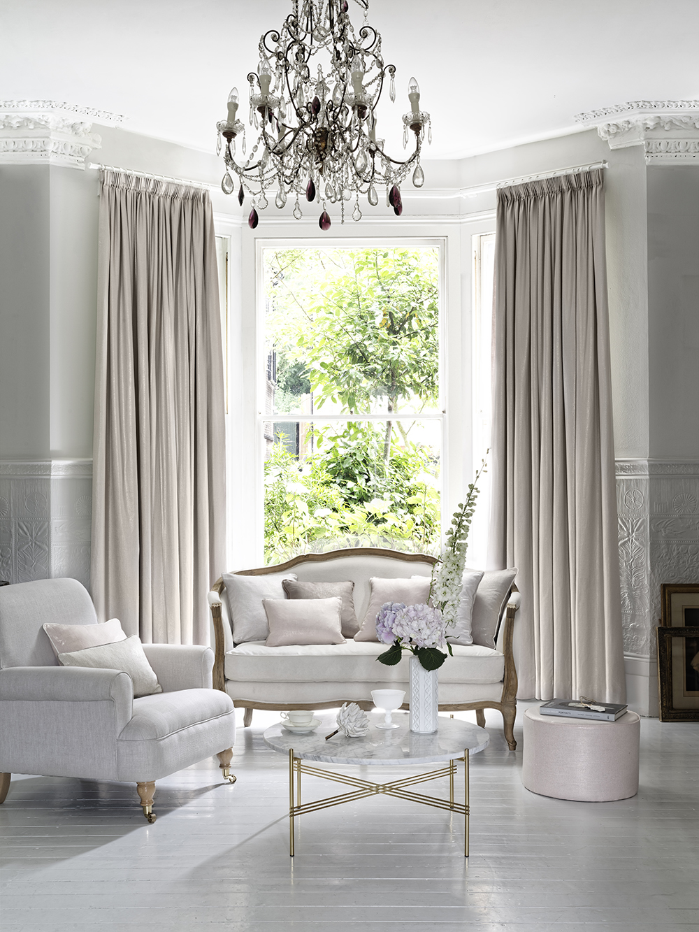 Opulent white living room with curtains and chandelier