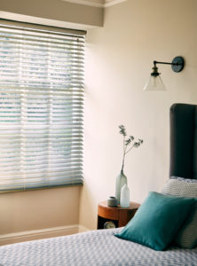 photo of bedroom with bed next to window that has grey venetian blinds fitted 