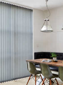 photo of dining room table next to window with grey vertical blinds fitted 