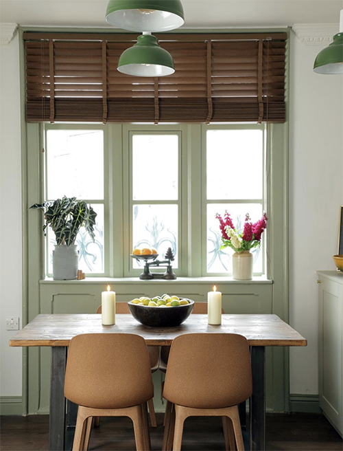 close up image of kitchen table in front of large window with wooden blinds