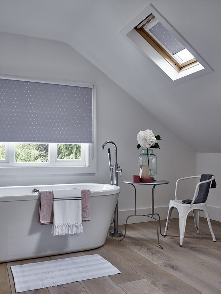 image of bathroom with bath tub underneath window with roller blinds fitted