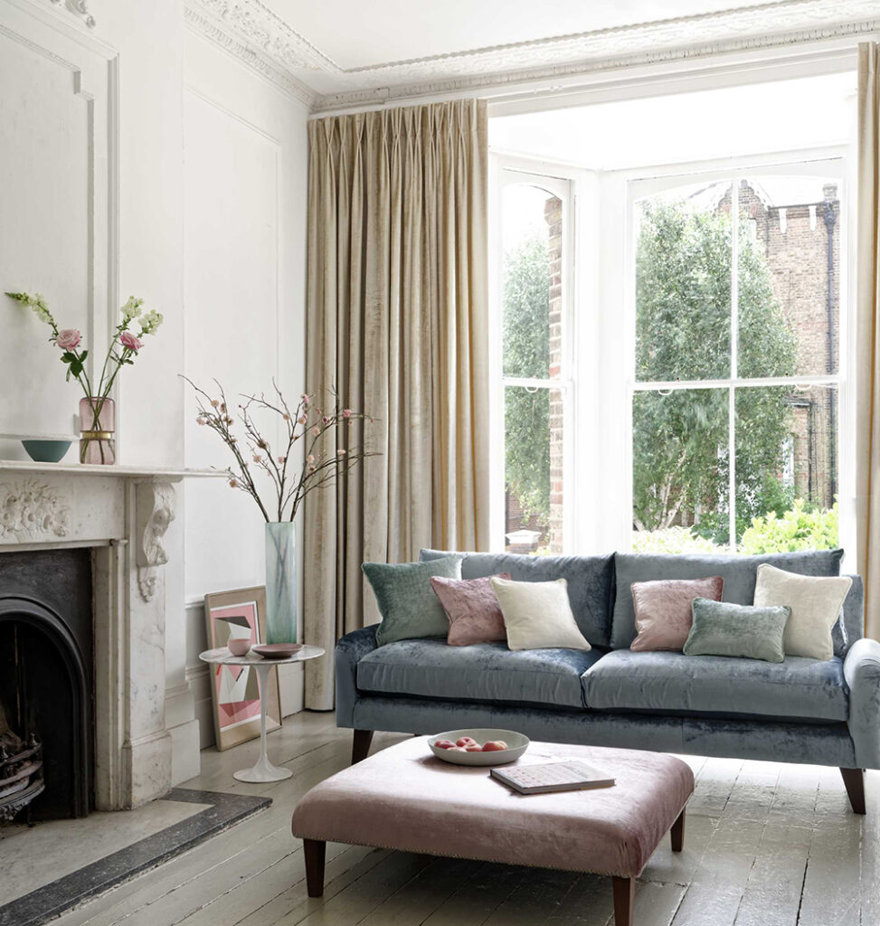 image of living room with sofa next to large window and fireplace