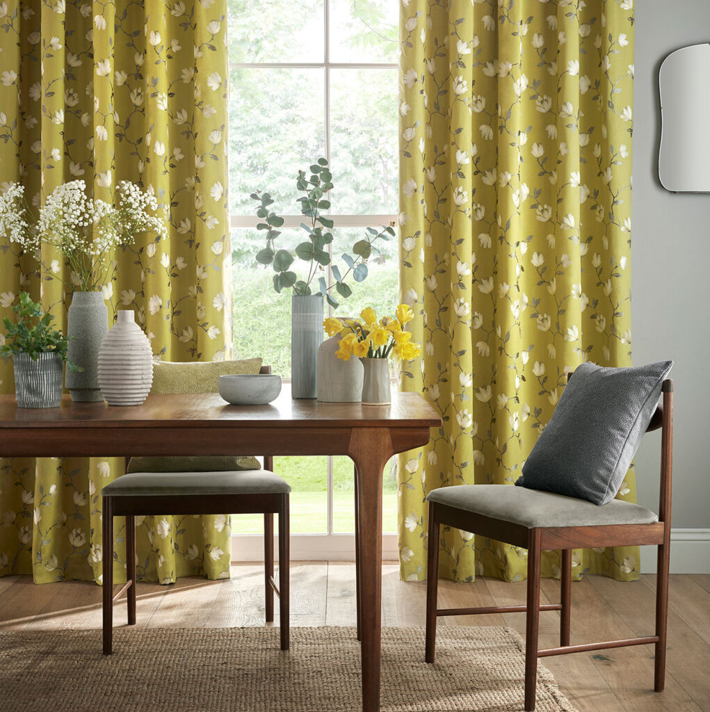 photo of bright yellow curtains in dining room with two chairs and grey cushions