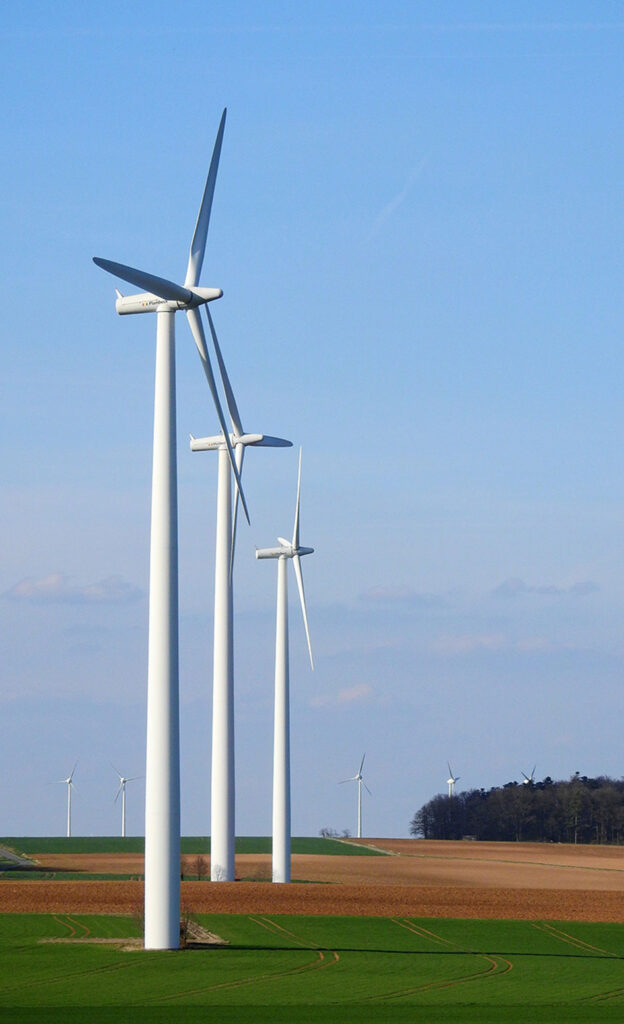 wind farms in field with blue sky