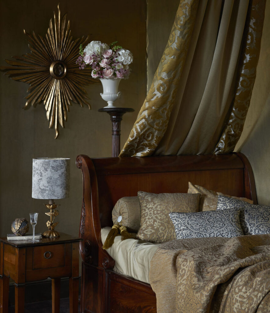 image of bedroom layout with brown oak bed with gold bedding 
