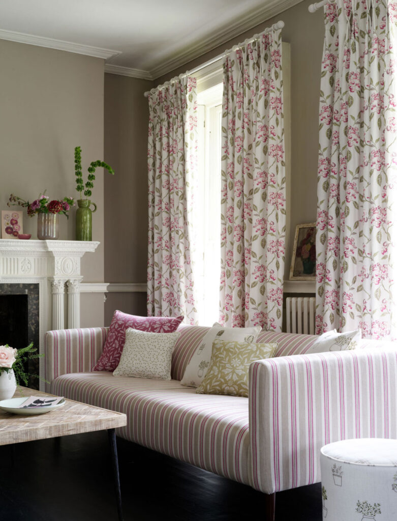 pinked striped sofa with white floral curtains to show design in the 1980s