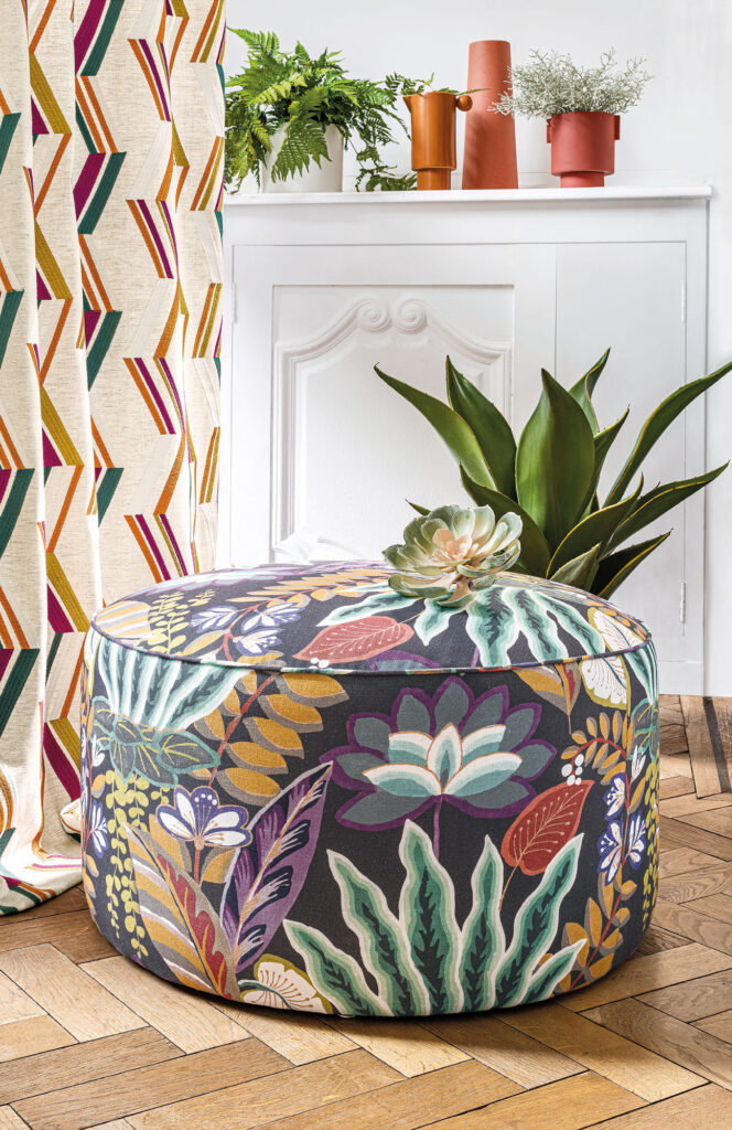 floral bean bag next to patterned curtain on wooden floor in white room 