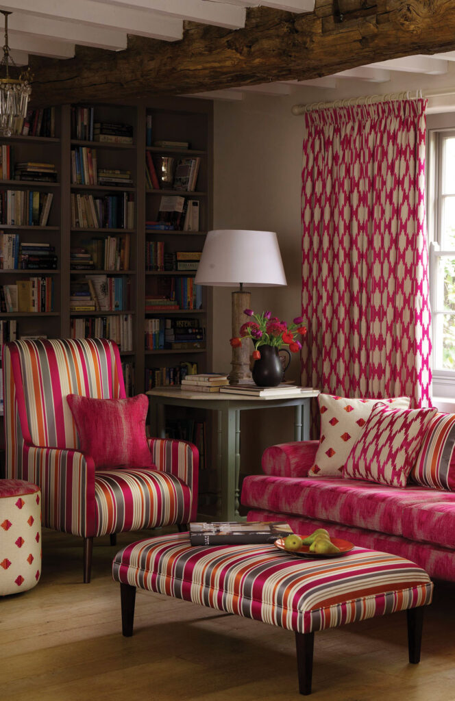 maximalist interior design example image with pink and white stripped sofa and patterned curtains 