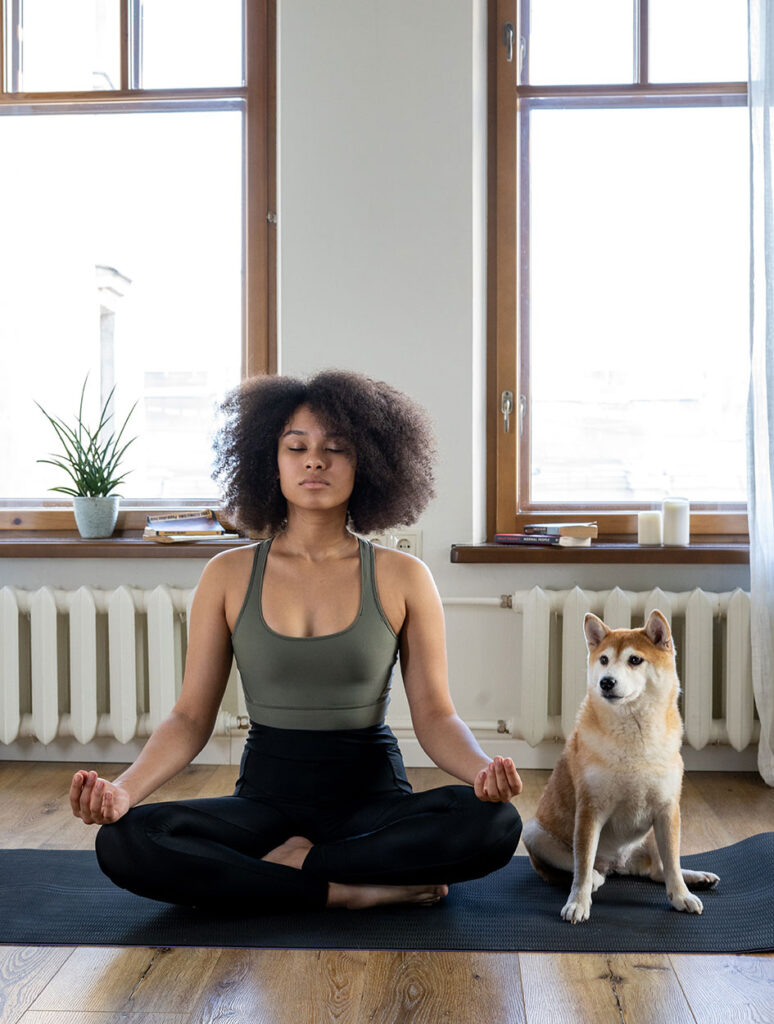 image of woman meditating next to dog to show tips for meditation for sleep