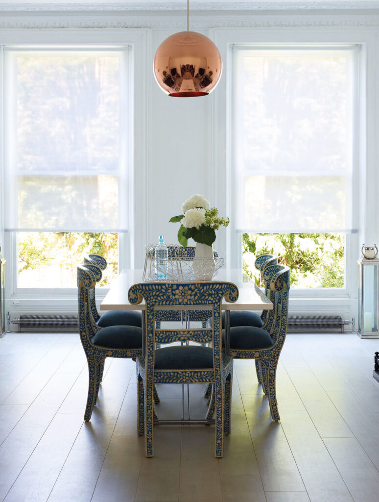 photo of dining room table and chairs with white blinds to show how tips for how to clean roller blinds work