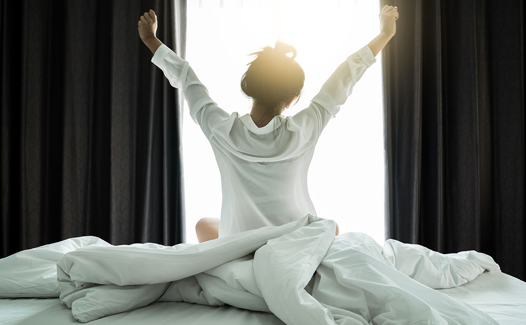 image of person waking up on their bed as a tip for mental health week uk