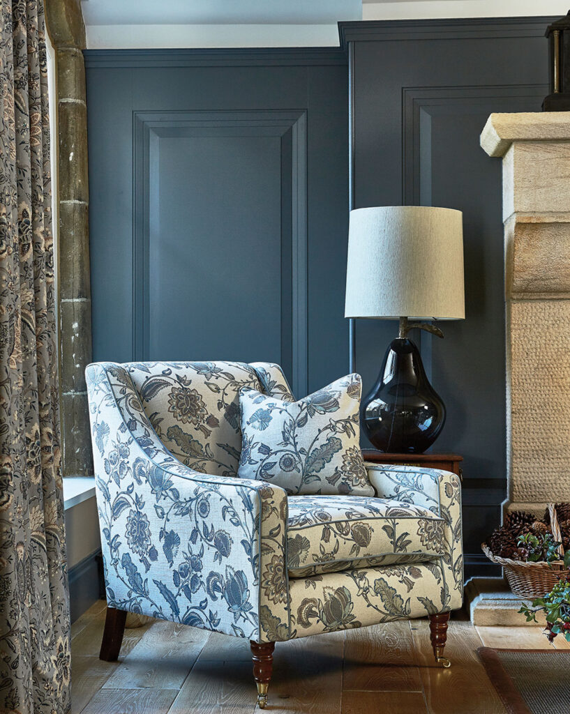 floral printed chair next to window in living room based in the english countryside 