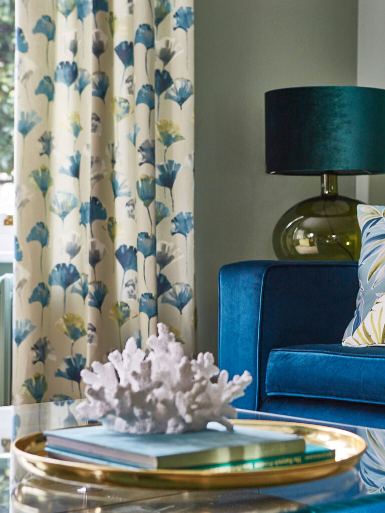 image of blue chair with floral curtains to show some living room curtain ideas