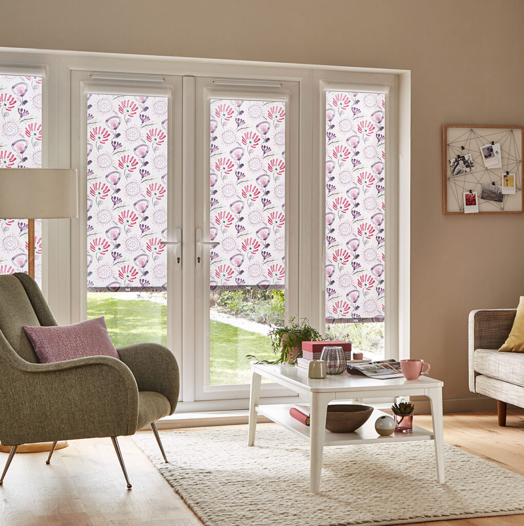 image of living room with green chair and sofa with patio doors dressed with pink Perfect Fit® blinds for patio doors 