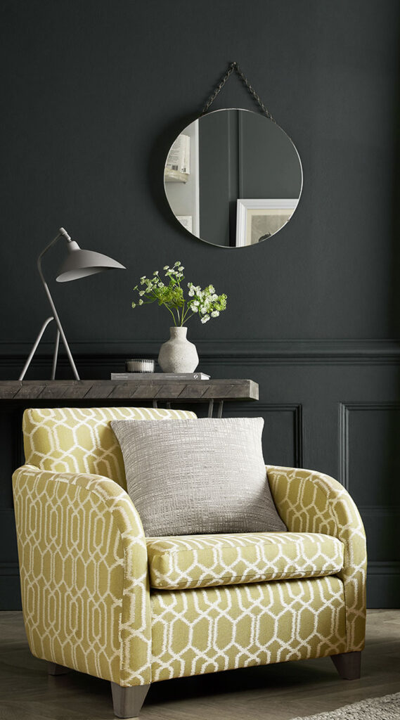 photo of an anthracite colour painted wall in living room with chair in front of it to show the type of colour anthracite is 