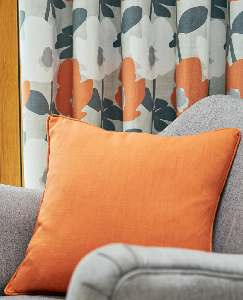 photo of orange cushion on grey sofa to show how to use the grey and orange colour combinations