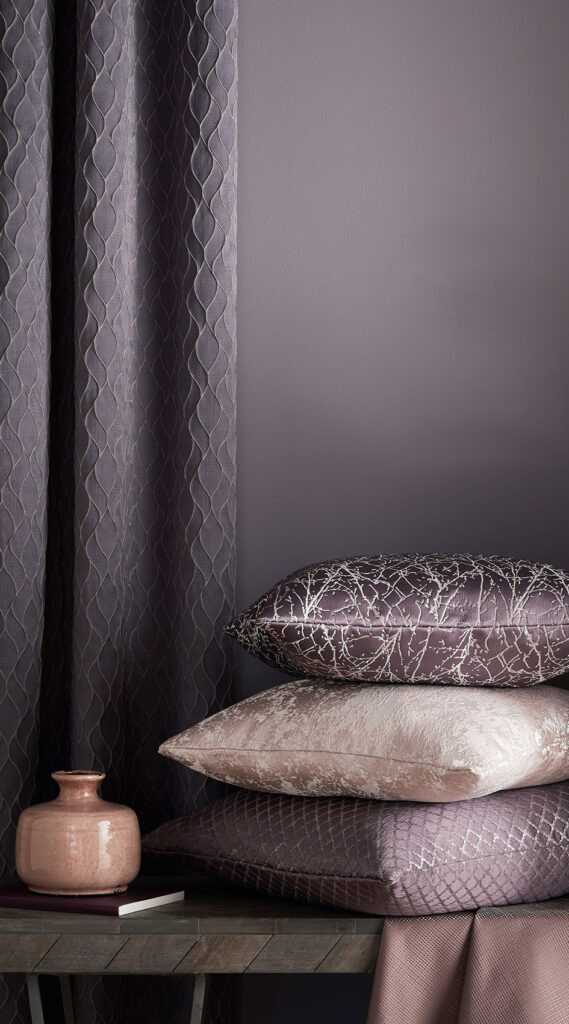 an image of anthracite grey and cream coloured cushions next to wall 