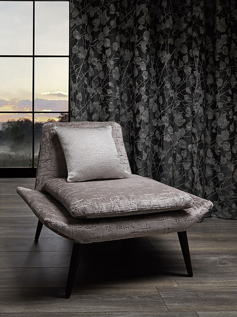 image of anthracite coloured chair and curtain in room next to large windows 