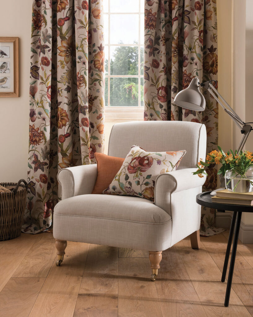 image of floral curtains next to chair with two cushions to show how village green interior design works 