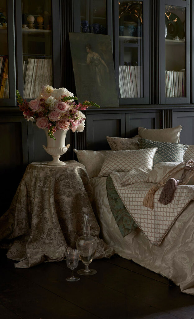 photo of flowers on table next to gold sofa in front of black cupboard
