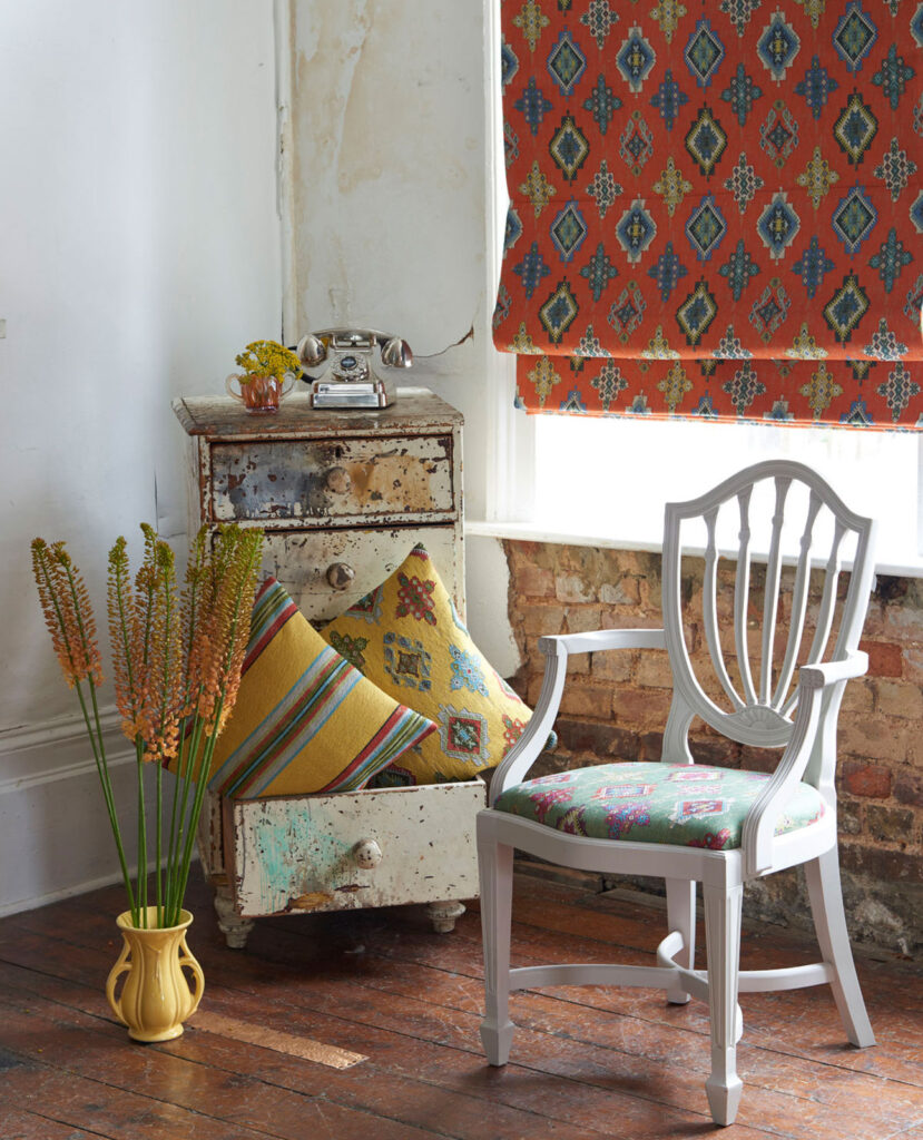 an image of white wooden chair next to window with central american inspired roller blinds 