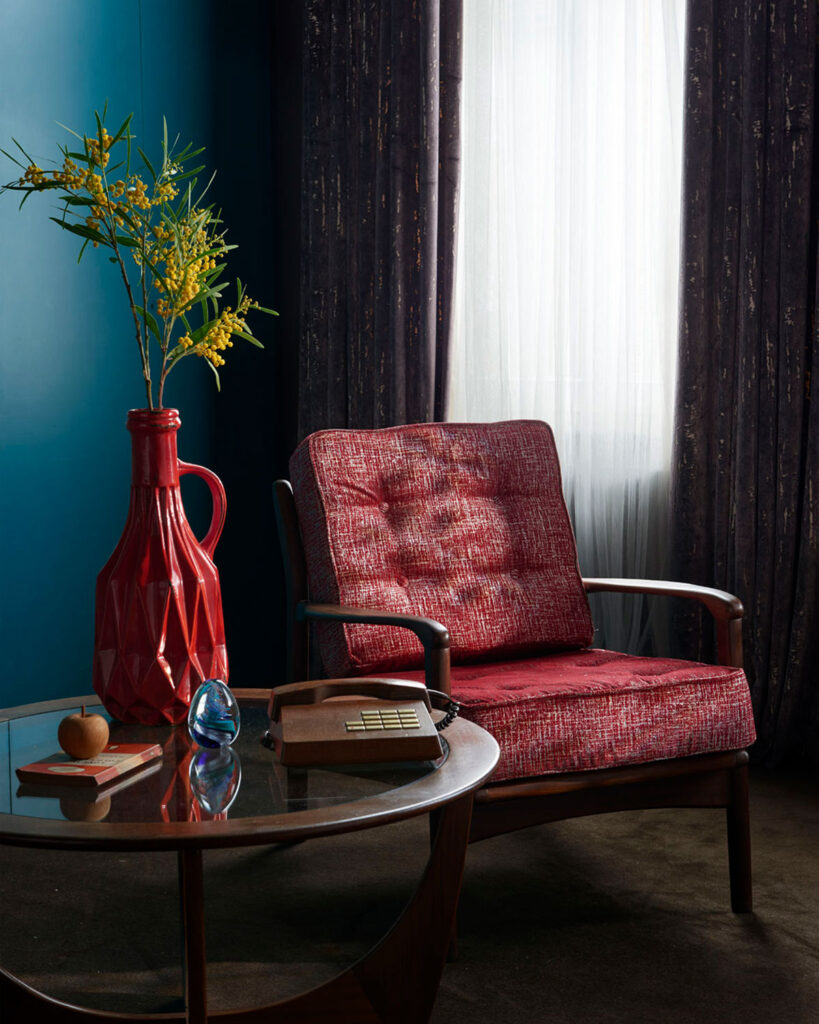 photo of stylish red chair next to mid century modern inspired curtain