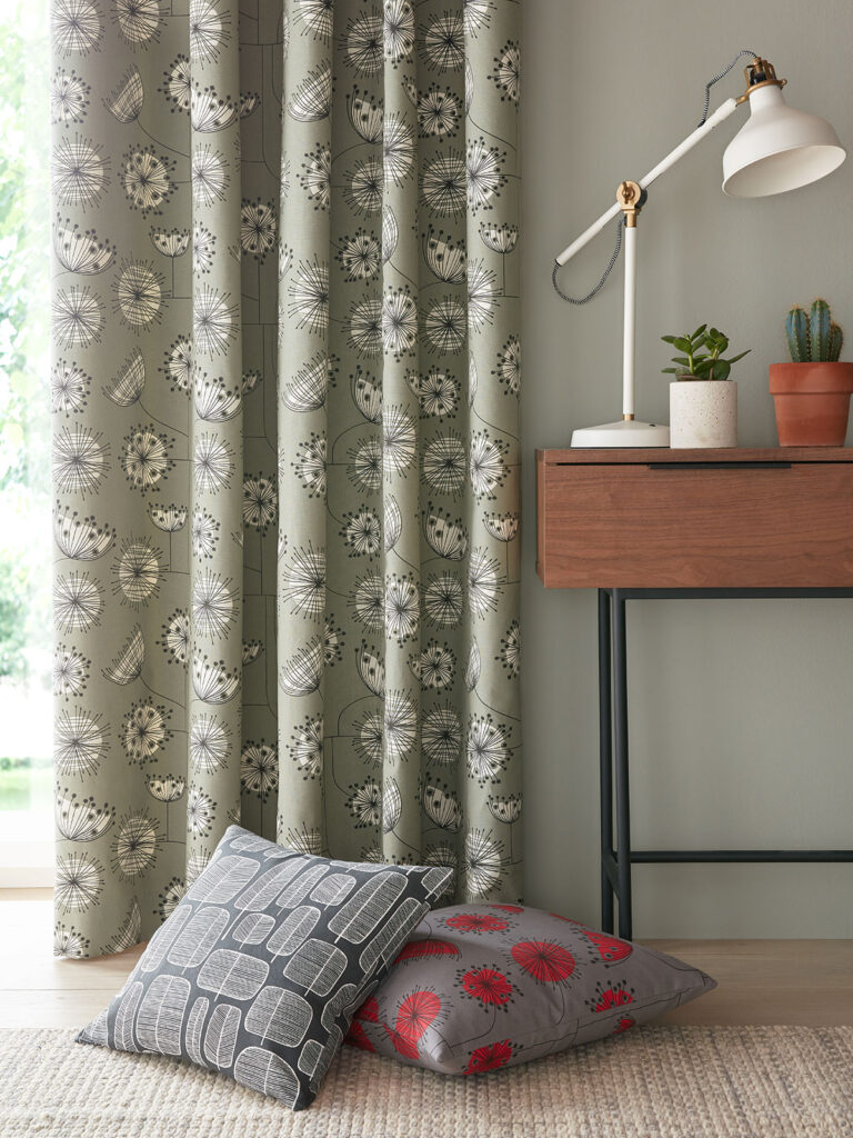 image if a soft green curtain next to table with lamp shade on it 