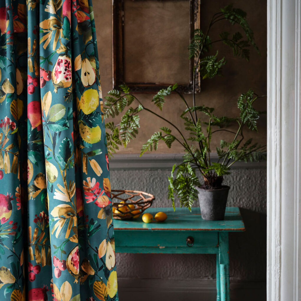 image of a soft green curtain with fruit on it next to green wooden table