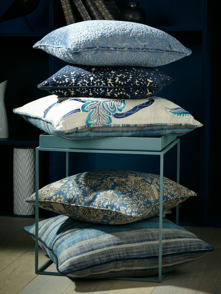 photo of different coloured blue cushions stacked on top of each other 