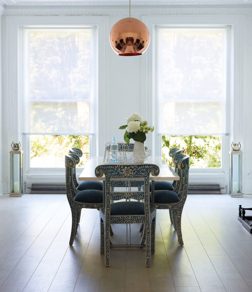 image of open planned dining room next to two large windows using roller blinds 
