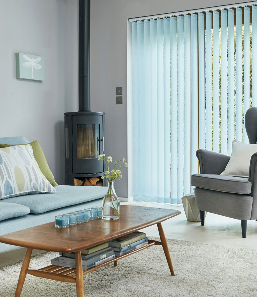 an image of living room with large patio door using a blue type of vertical blinds 