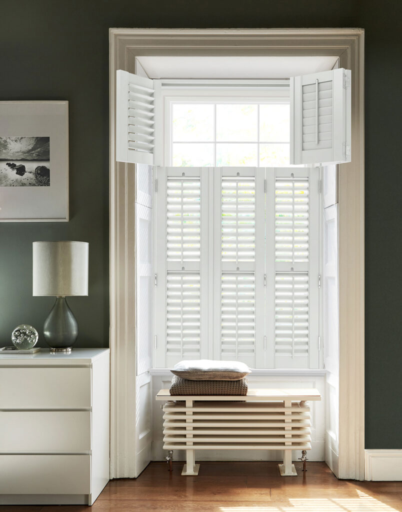 image to show example of white plantation shutters being used in green themed living room  