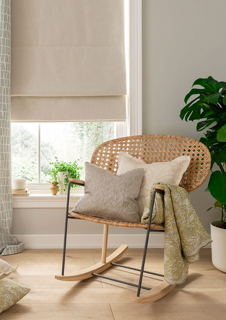 image of chair next to window to show how blackout roman blinds are used to block out light 