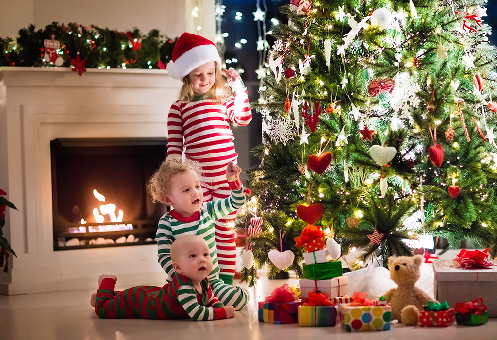 image of two children putting Christmas decorations on the tree