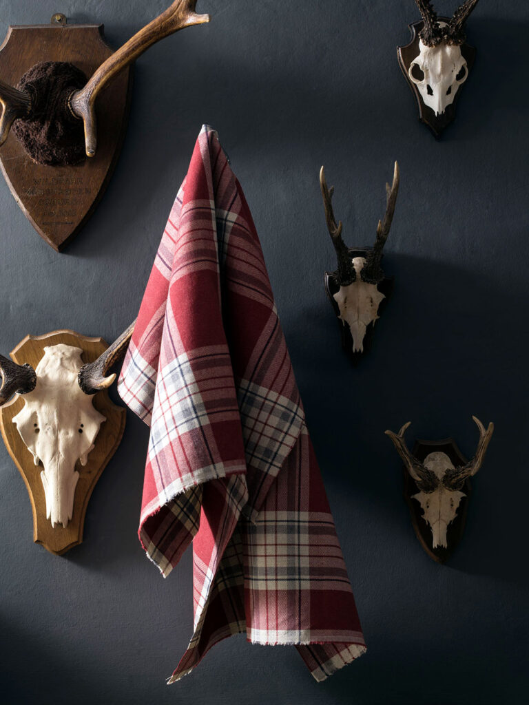 photo of red tartan material hanging on the wall 