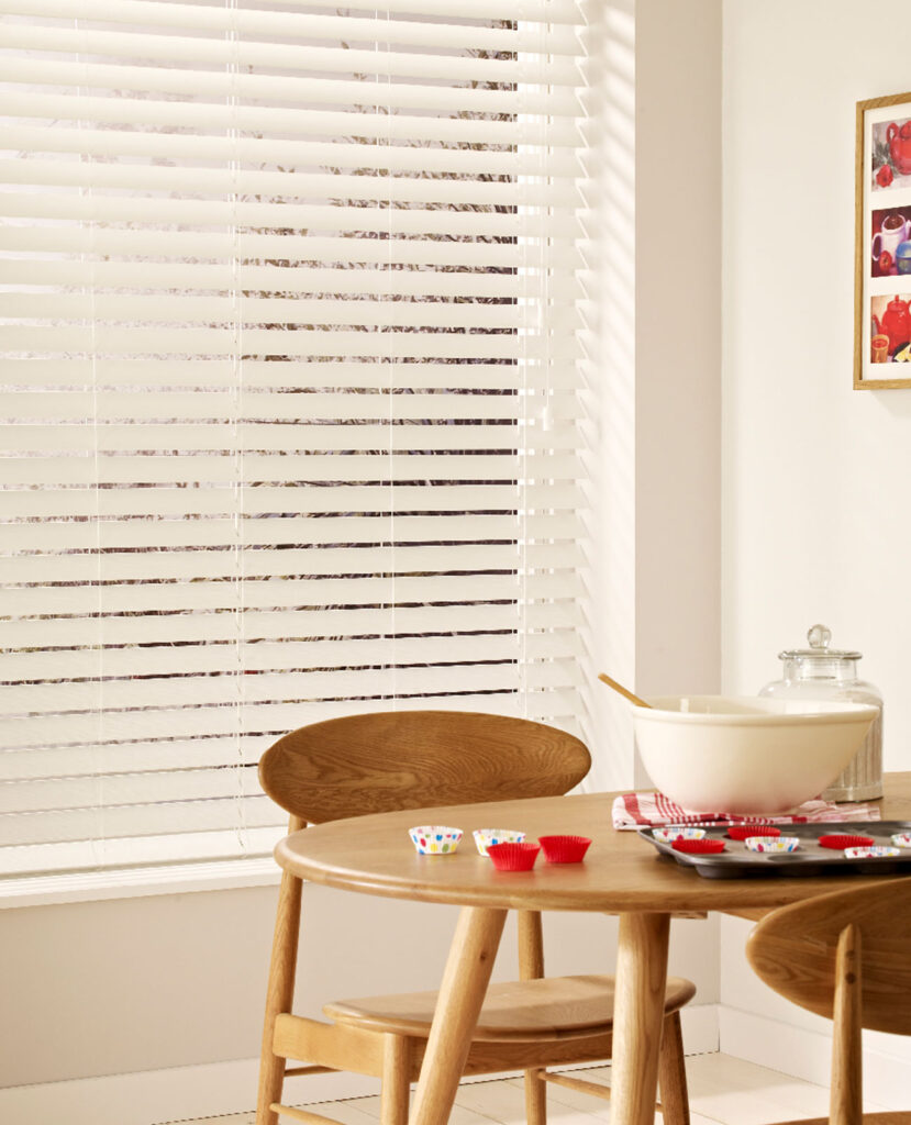 photo of wooden kitchen table in front of window and venetian blinds 