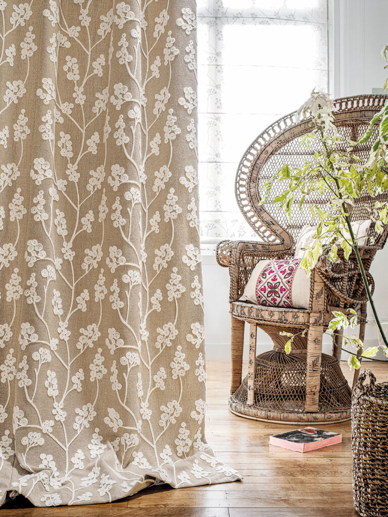 photo of neutral coloured curtain next to wicker chair 