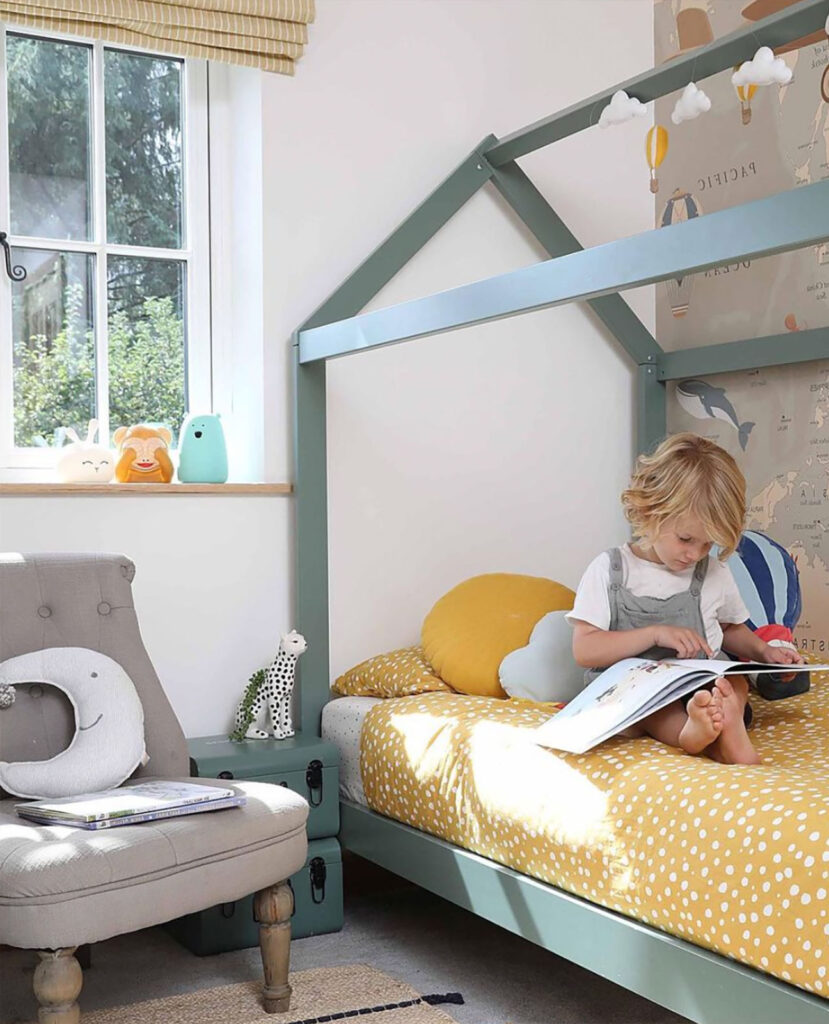 image of child sat on bed reading a book