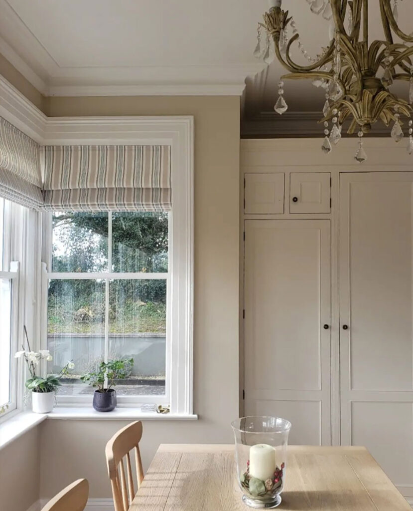 photo of dining table in kitchen in front of large windows 