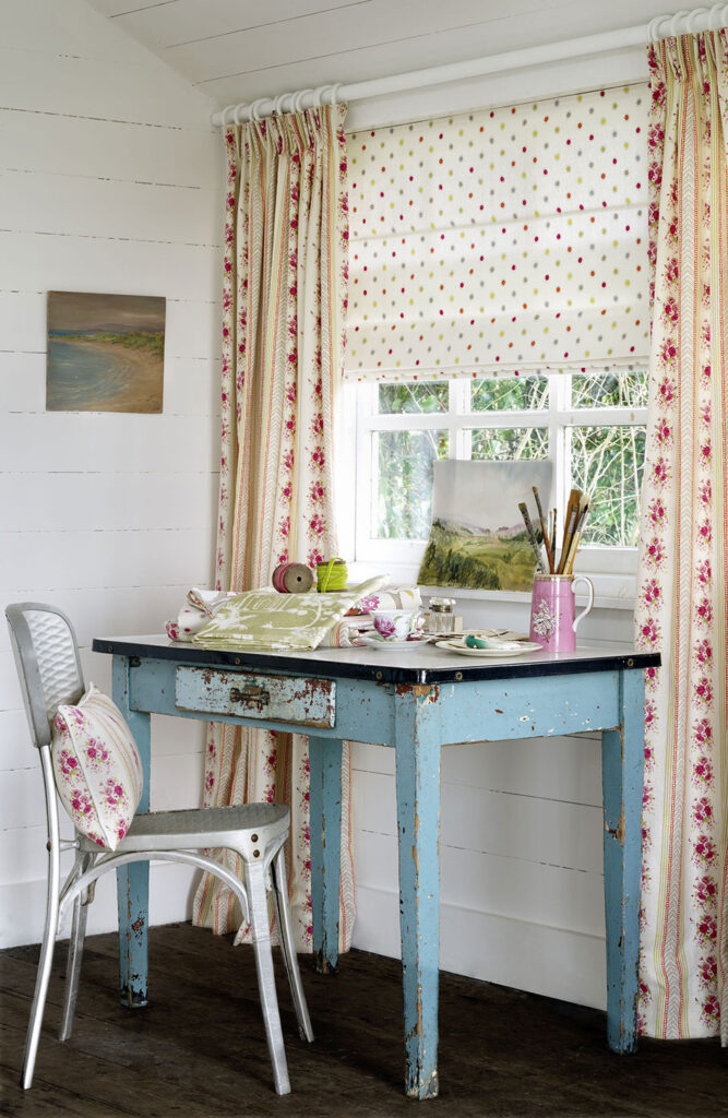 photo of a desk and chair in front of a window with candy floss pink curtains