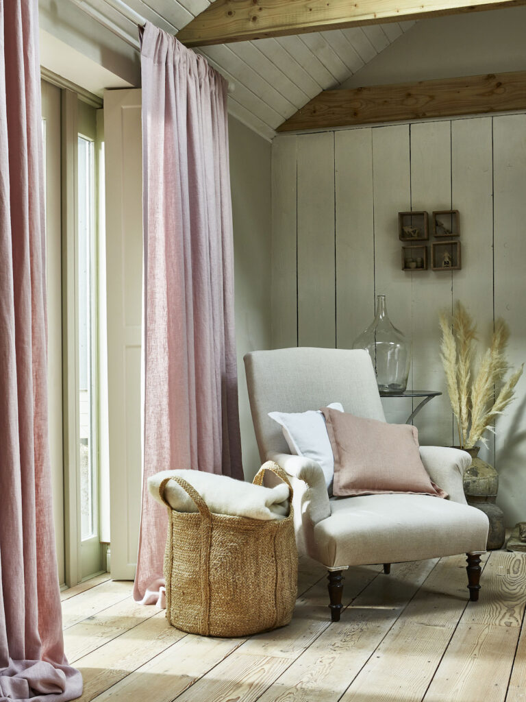 image of a chair inside a cottage next to candy floss coloured curtains 