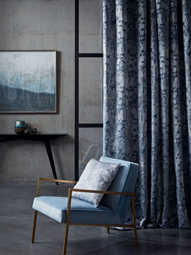 close up image of chair next to a tranquil blue curtain 